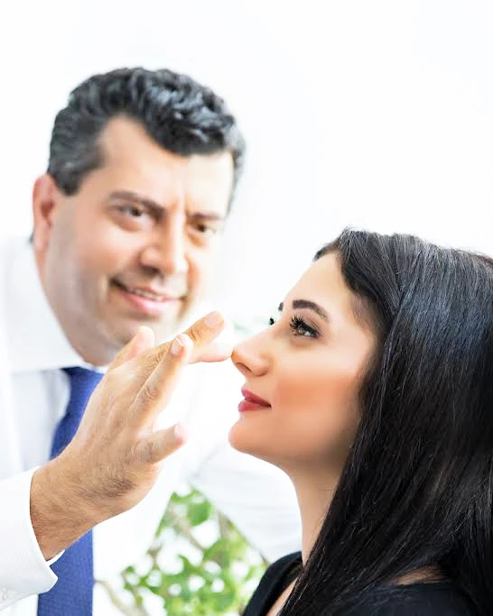 Op. Dr. Cenk Teker İstanbul'daki kliniğinde bir burun estetiği hastasını muayene ederken